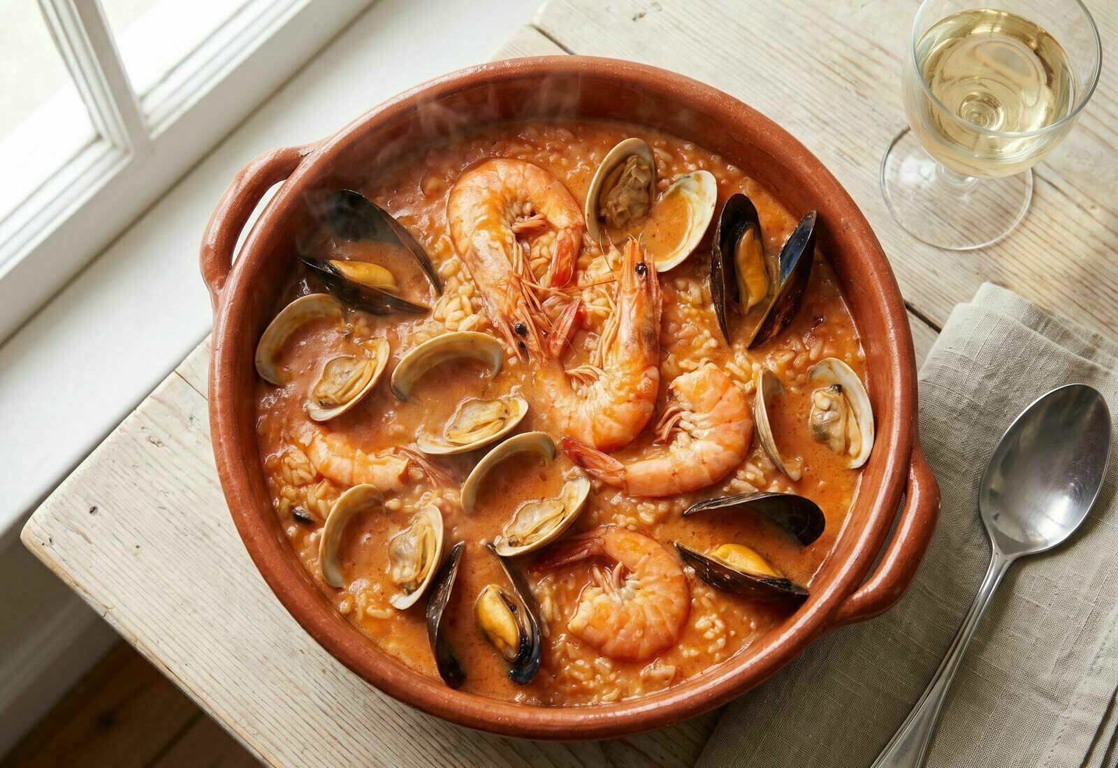 Arroz de marisco servido numa cataplana de cobre tradicional, com camarão, mexilhão e amêijoas